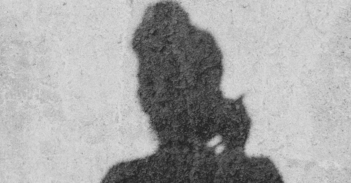 Black and white shadow of a person on a rough textured surface, creating an intriguing silhouette.